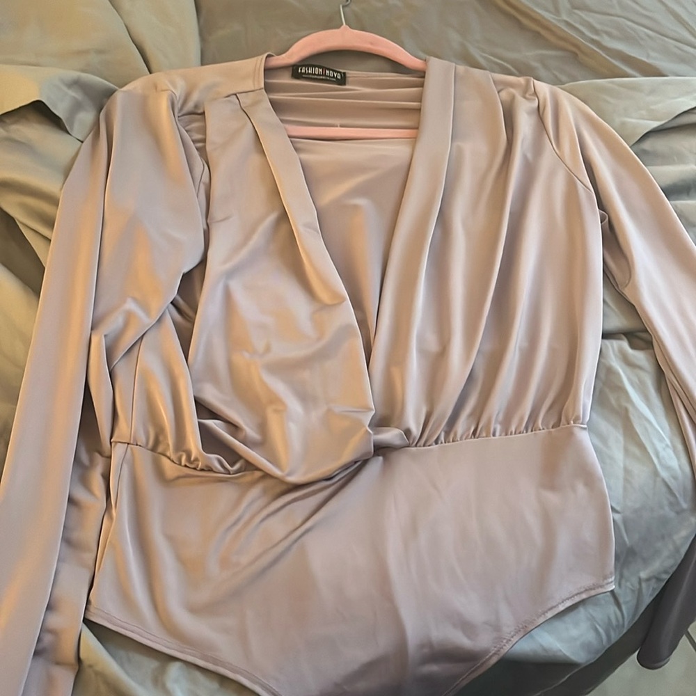 Fashion nova body suit in purple low cut v and in mint condition.